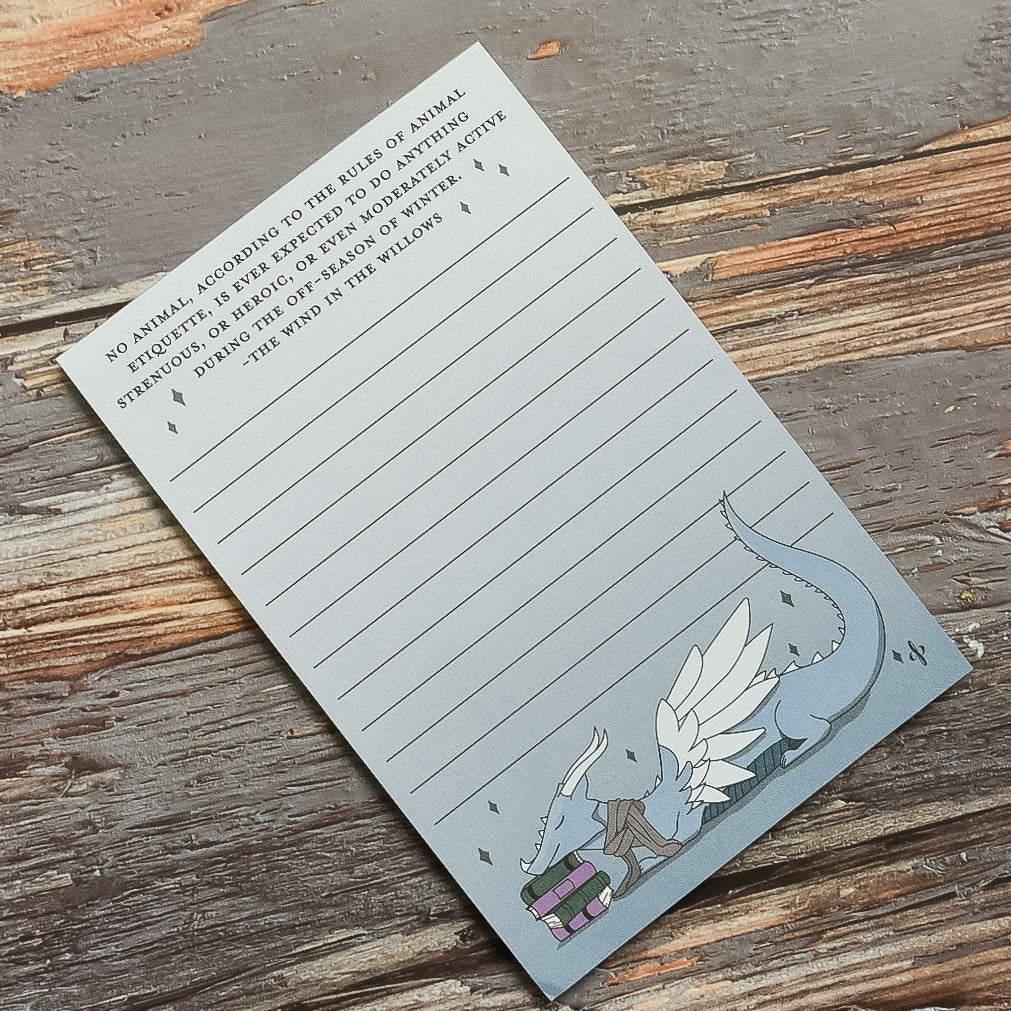 Drawing of a winged blue dragon sleeping on a pile of books cute notepad