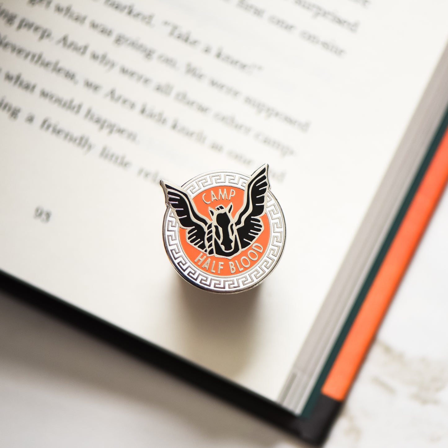 blackjack horse membership style pin on a Percy Jackson book