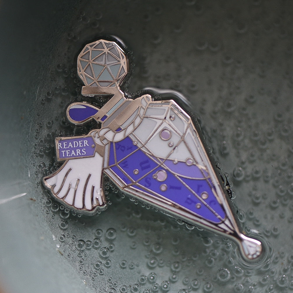 Purple and silver potion bottle enamel pin with a tag that says Reader Tears