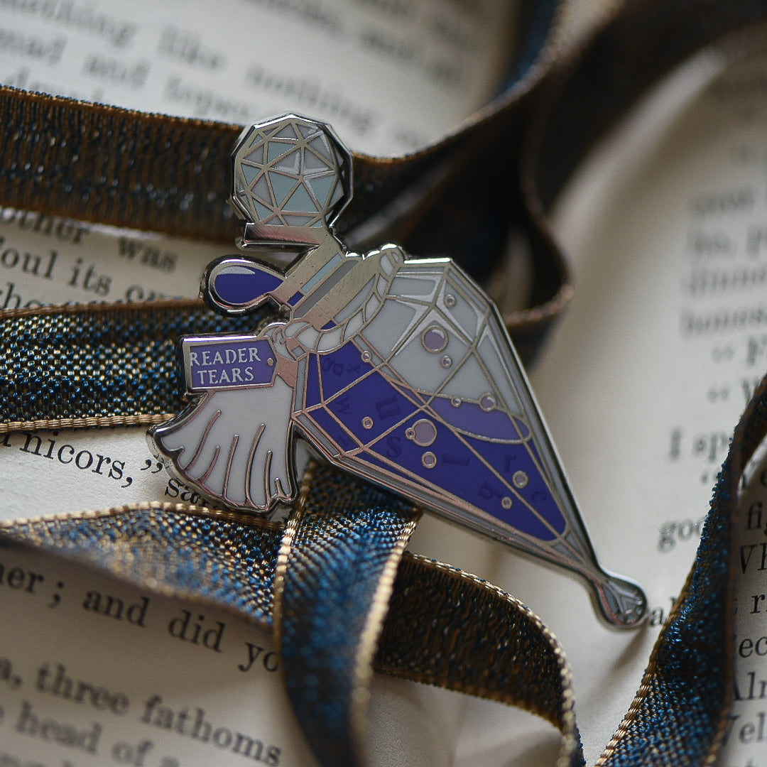 Purple and silver ornate potion bottle enamel pin with a tag that says Reader Tears