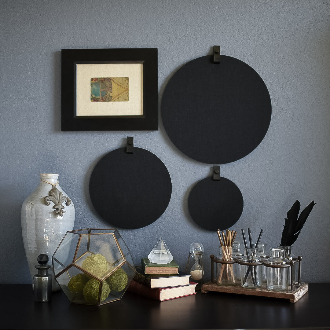 Three round felt boards for organization with black tabs hanging on a cozy wall