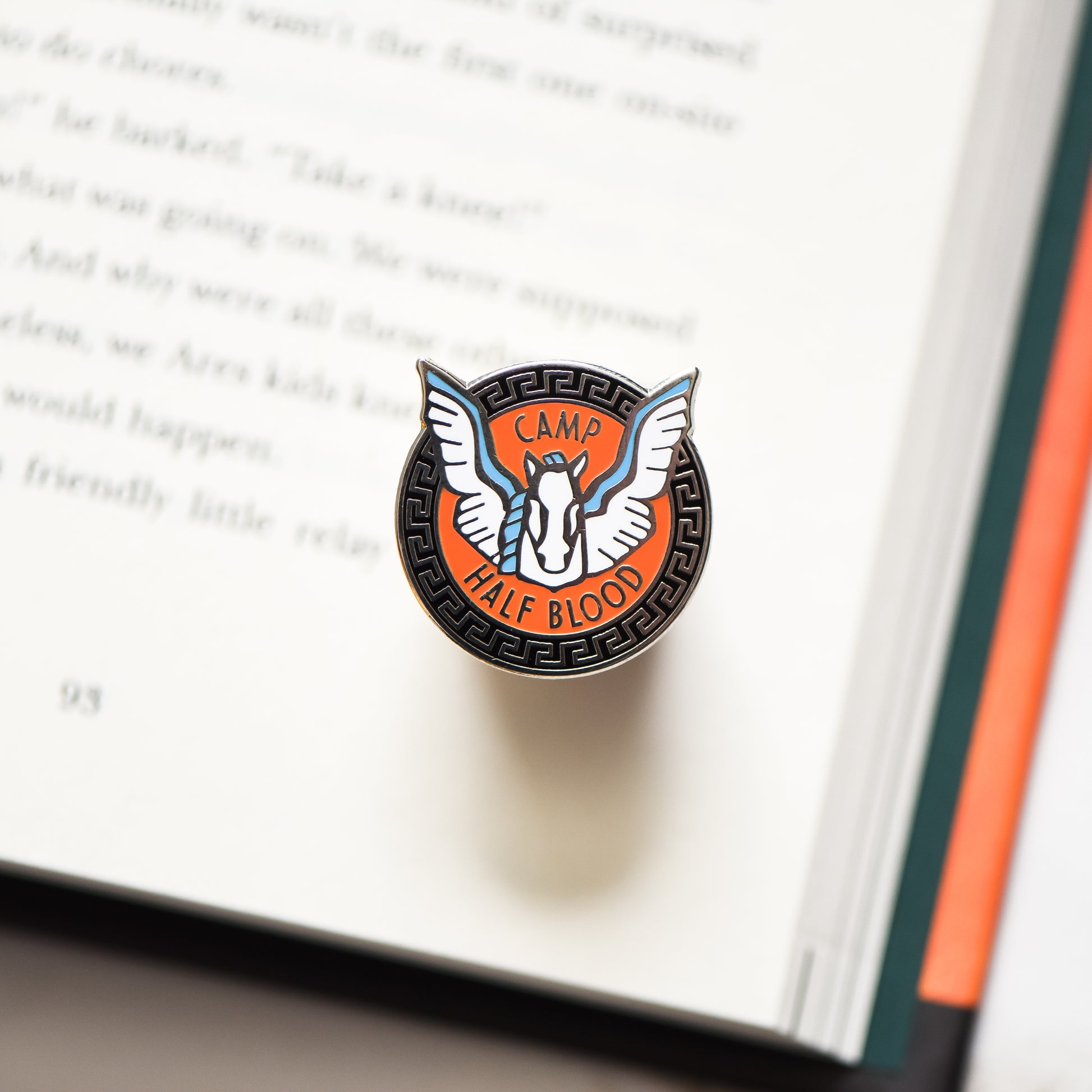 Pegasus horse membership style pin on a Percy Jackson book