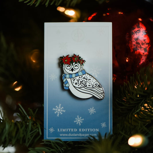 Snowy owl wearing a wreath of poinsettias enamel pin