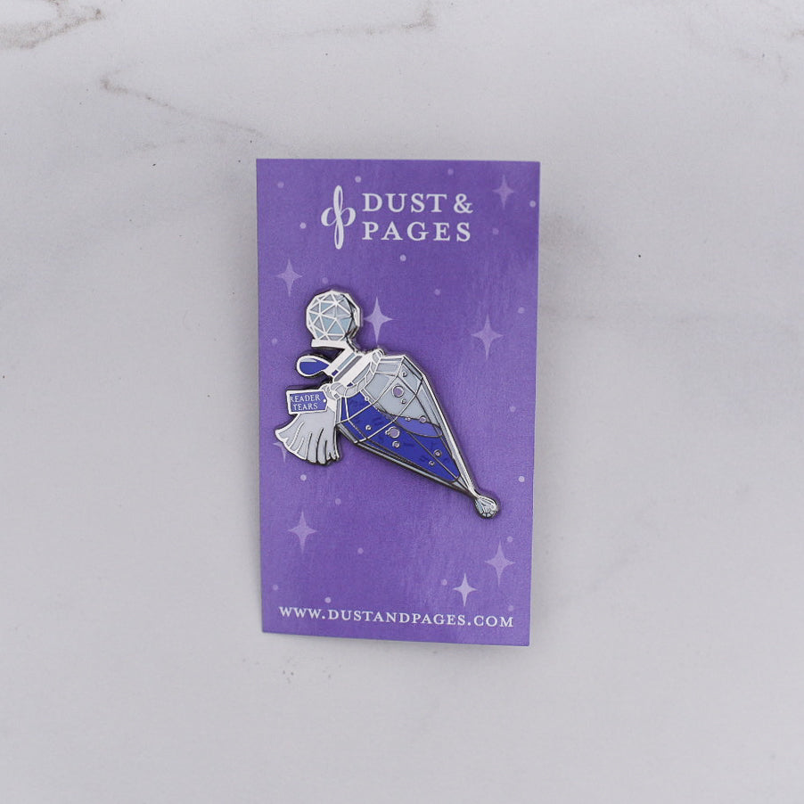 Purple and silver potion bottle enamel pin with a tag that says Reader Tears on a purple card