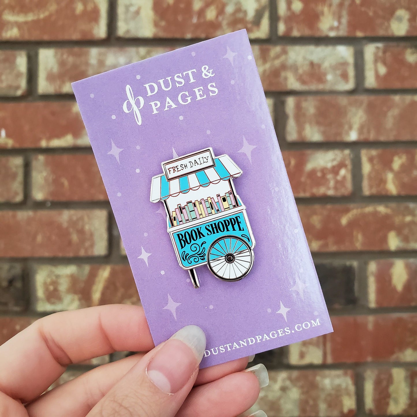 Girl holding a kawaii pastel book shop vendor cart hard enamel pin