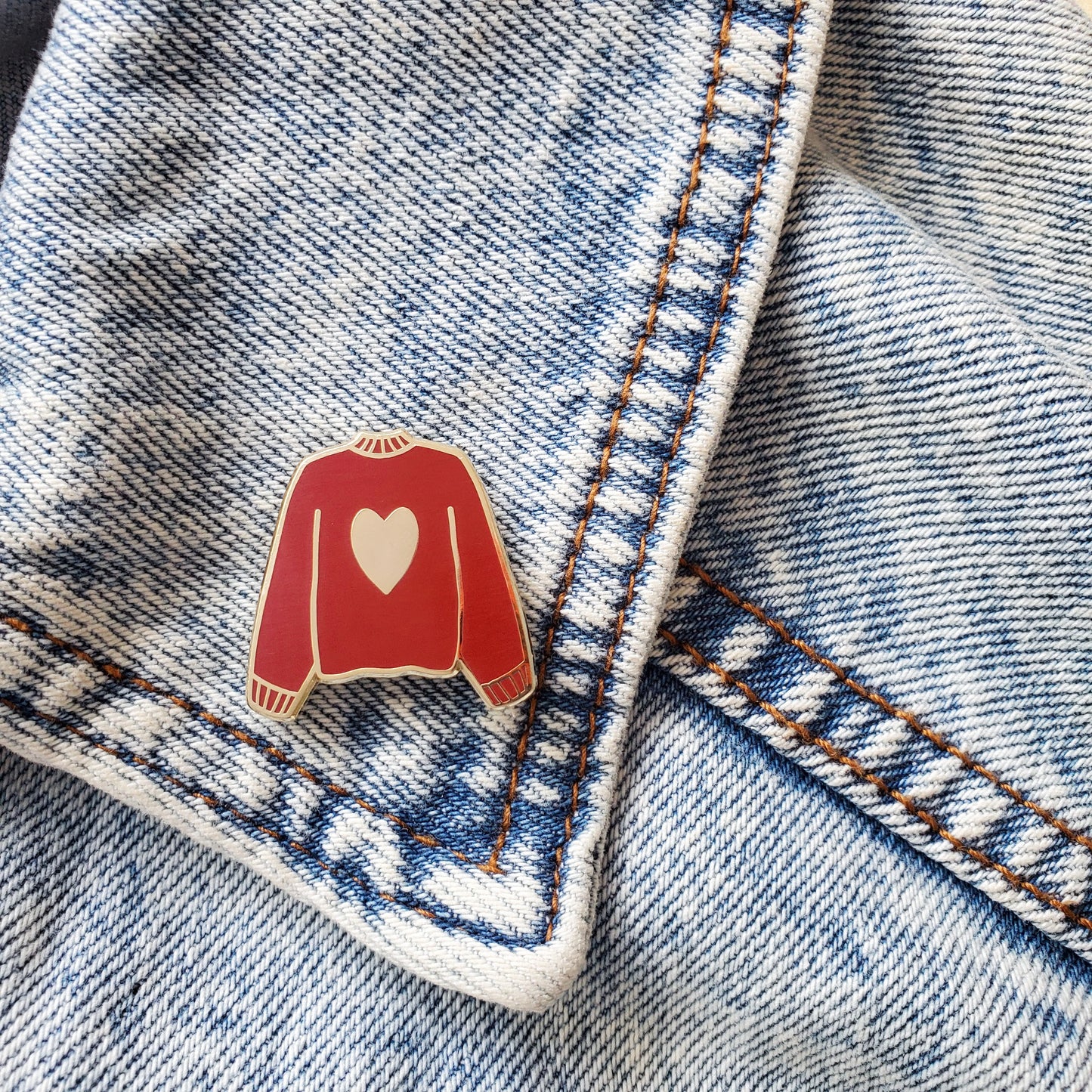 Maroon red hand stamped heart sweater enamel pin on a jean jacket