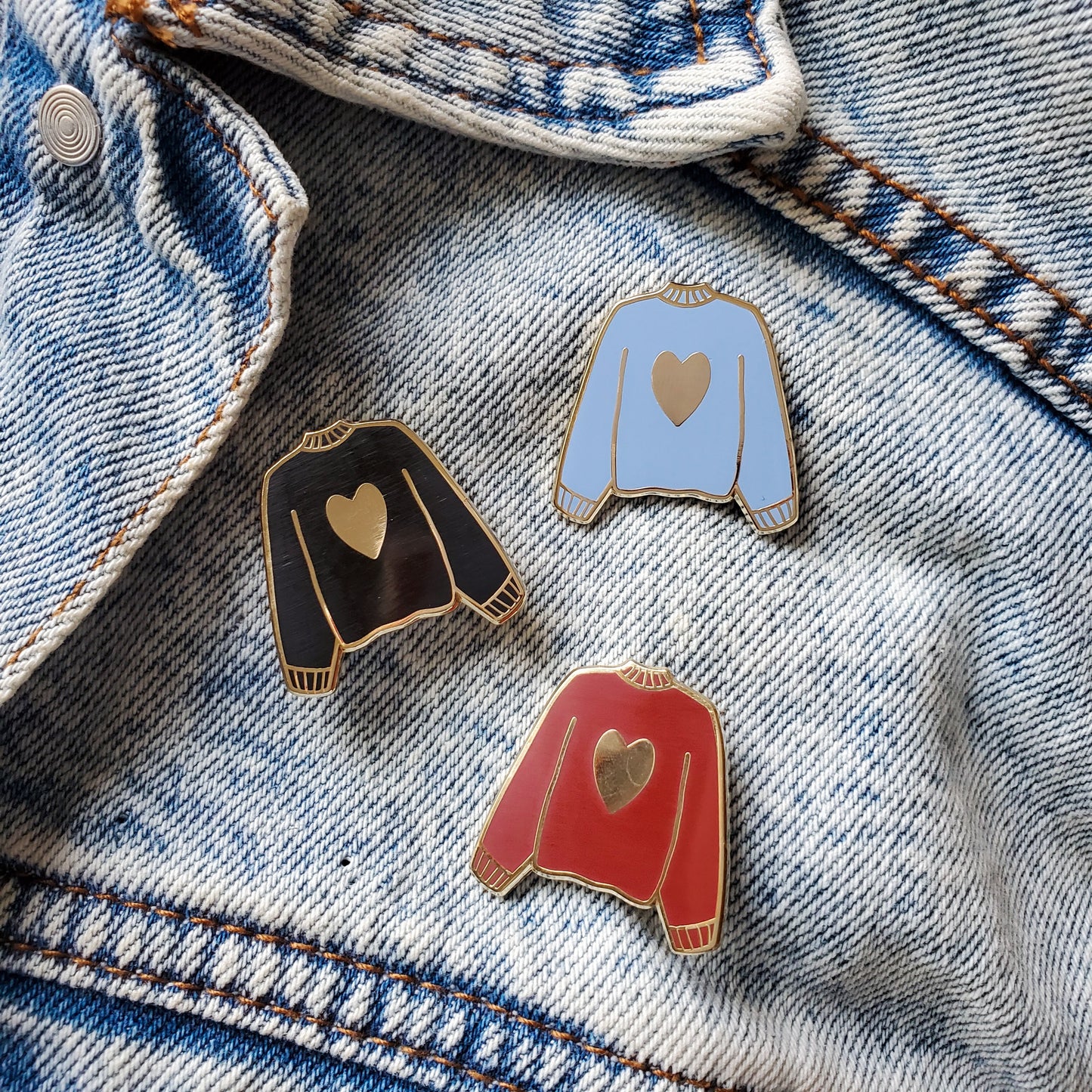 Maroon red black and blue hand stamped heart sweater enamel pin on a jean jacket