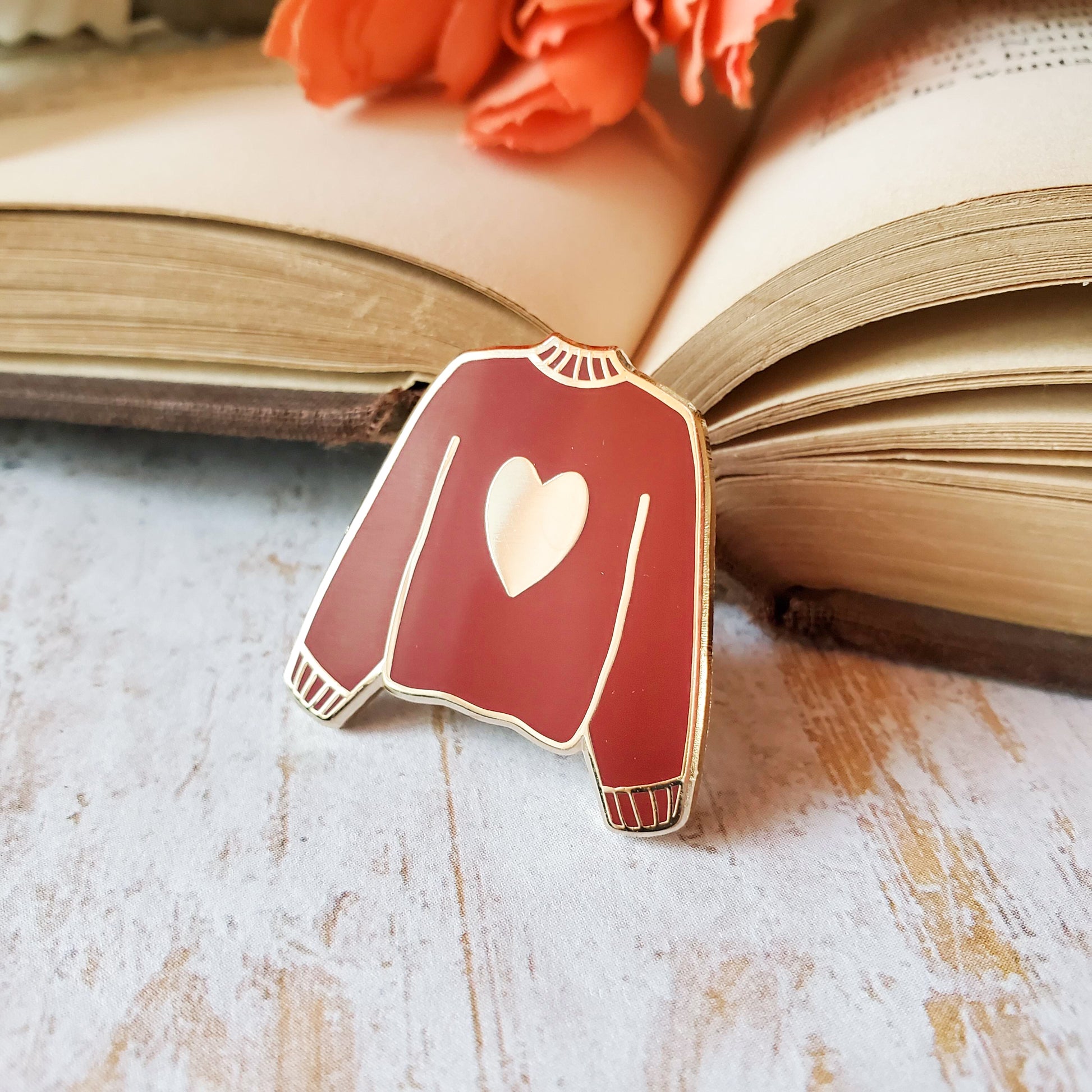 Maroon red hand stamped heart sweater enamel pin with a book
